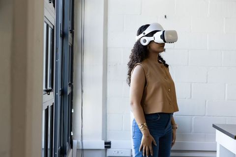 African American woman exploring virtual reality in modern office with VR headset