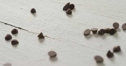 Scattered Chocolate Chips on Rustic White Surface