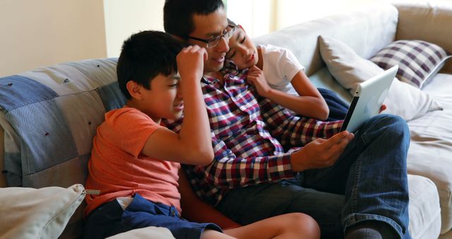 Father Reading Tablet with Kids on Couch, Family Relaxing at Home - Download Free Stock Images Pikwizard.com