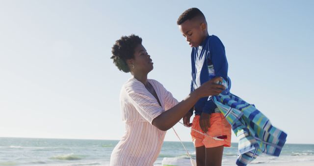 Caring Mother Dressing Son at Sunny Beach - Download Free Stock Images Pikwizard.com