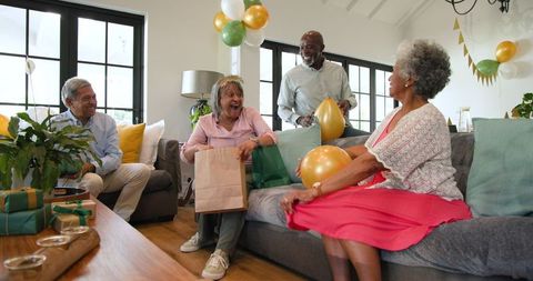 Happy Senior Friends Celebrating Birthday with Gifts
