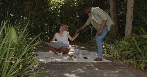 Couple Sharing Romantic Picnic in Lush Garden