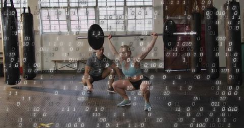 Female athlete lifting overhead squat with barbell while coach spotting, binary overlay