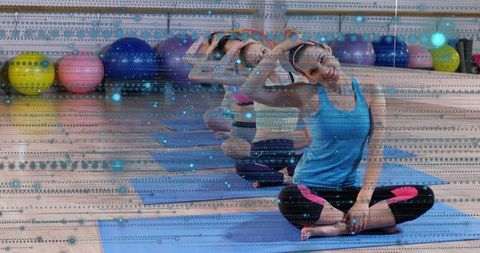 Smiling woman stretching on blue mat with mirrored motion and colorful balls