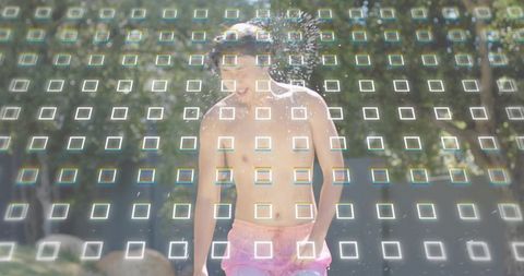 Shirtless asian man laughing, running through park sprinkler wearing pink trunks