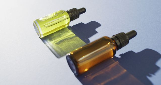 Yellow and Brown Glass Dropper Bottles on Flat Surface with Shadows - Download Free Stock Images Pikwizard.com