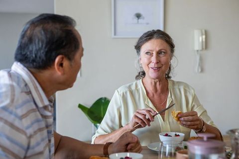 Senior Couple Enjoys Breakfast Together Sharing Berries and Pastry
