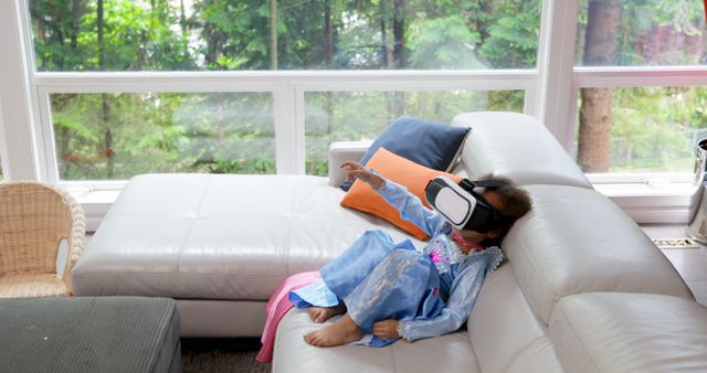 Young Girl Using Virtual Reality Headset on Sofa in Modern Living Room - Download Free Stock Images Pikwizard.com