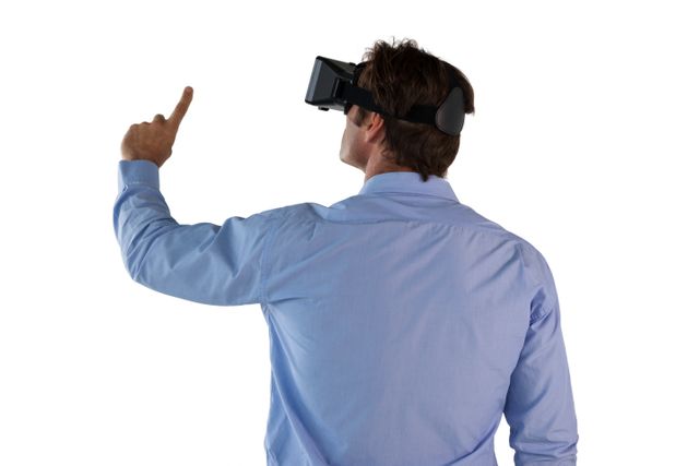 Businessman wearing VR glasses and pointing, showcasing use of virtual reality in professional settings. Ideal for illustrating concepts of modern technology, innovation in business, and digital transformation in the workplace.