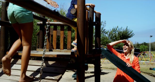 Woman Watching Children Playing Outdoors on Wooden Playground - Download Free Stock Images Pikwizard.com