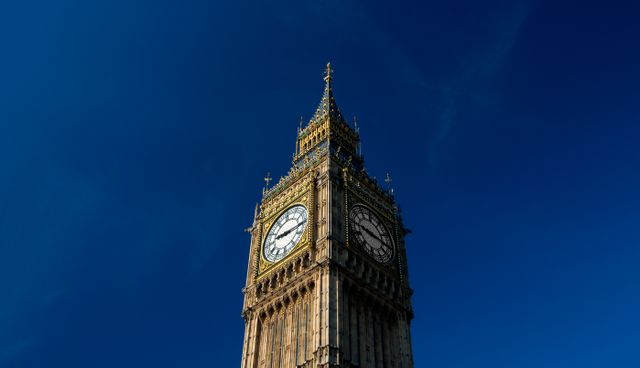 Big Ben tower standing against a clear blue sky, highlighting its intricate architectural details. Ideal for travel and tourism websites, promoting London landmarks, educational materials about UK history, and postcards.
