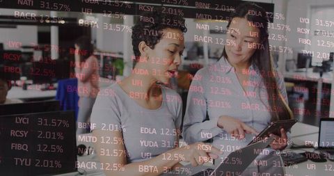 Diverse Female Professionals Collaborating on Financial Data Analysis in Modern Office