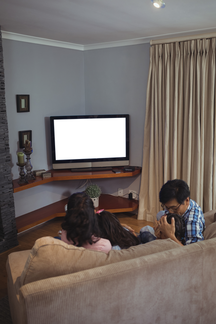 Happy Family Watching Television on Living Room Sofa – Transparent TV Screen - Download Free Stock Videos Pikwizard.com