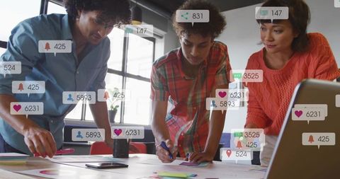 Creative team collaborating on marketing charts with social media notification badges and analytics