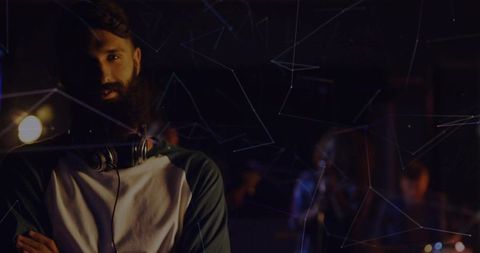 Bearded Musician With Headphones in Tech-Inspired Studio