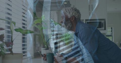 Man checking smartphone leaning on kitchen counter with dna helix overlay, soft light