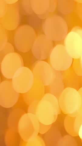 Vertical video drifting golden bokeh pulsing warm ambient backdrop for calming visuals
