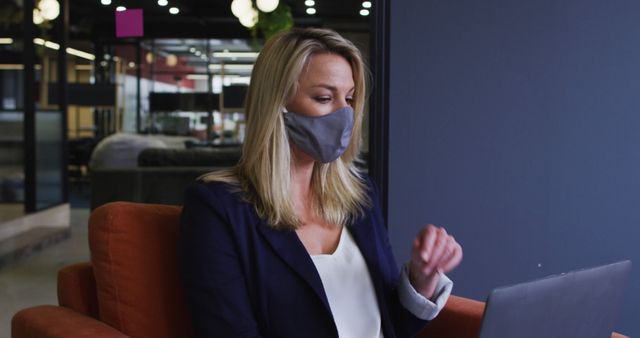 Businesswoman in Mask Working on Laptop in Modern Office - Download Free Stock Images Pikwizard.com