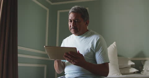Senior Man Using Tablet in Bedroom for Self-Retirement