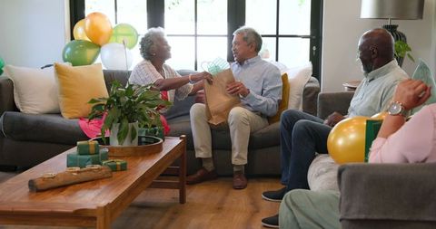 Senior Friends Celebrating Birthday with Gifts in Cozy Living Room