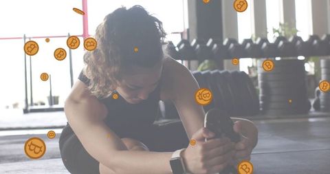 Female athlete stretching in gym with bitcoin crypto coin overlays fitness concept
