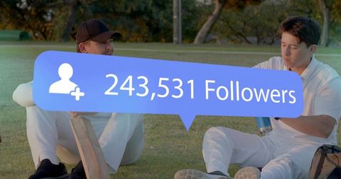 Cricket teammates celebrating social media milestone while resting on sunlit outfield