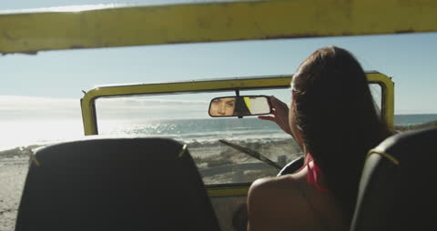 Woman Relaxing in Beach Buggy by the Ocean