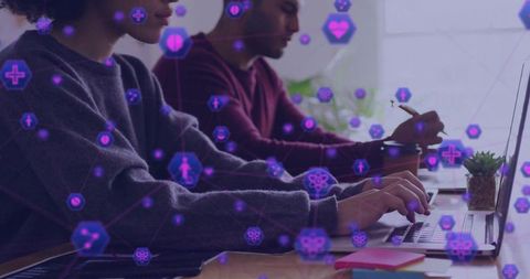 Collaborative duo typing and taking notes with purple data visualization overlay analytics