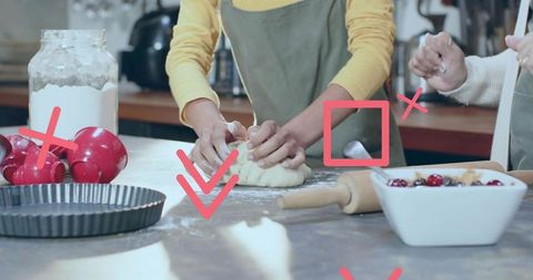 Asian woman kneading dough on kitchen counter with rolling pin, tart pan and fruit filling