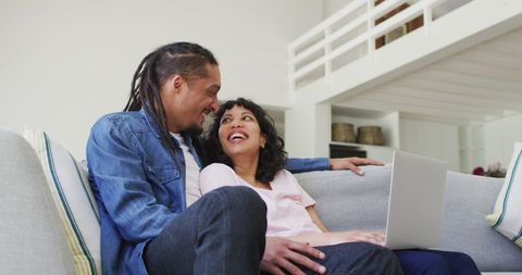 Couple Relaxing on Couch with Laptop at Home