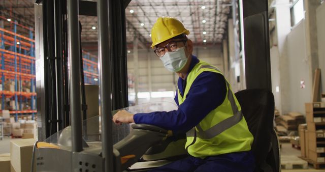 Portrait of asian male worker wearing safety suit and face mask in warehouse. global business, shipping and delivery during covid 19 pandemic.