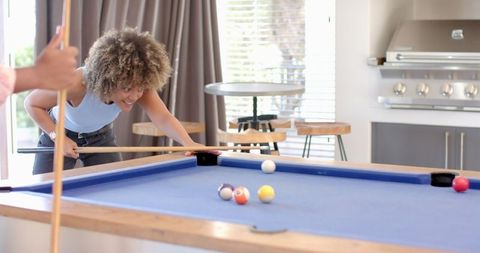 Smiling woman playing billiards in social knot