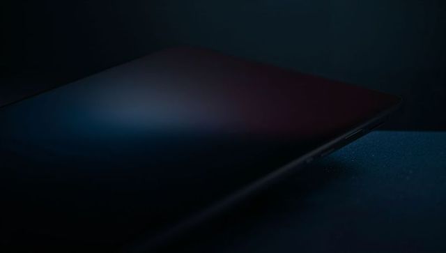 Sleek dark tablet resting on tabletop with usb-c port, moody rim light, minimal gradient display