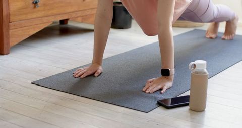Asian Woman Practicing Plank on Yoga Mat at Home for Fitness