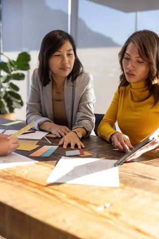 Female designers collaborating on creative project with color swatches