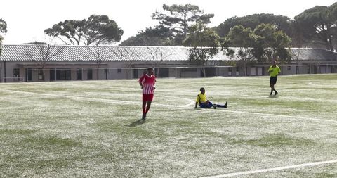 School soccer game on sunny day with enthusiastic players