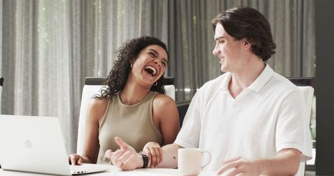 Happy multiracial couple with laptop relaxing