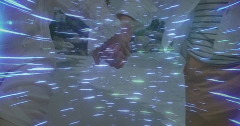 Couple holding hands under blue light streaks, symbolizing love and connection