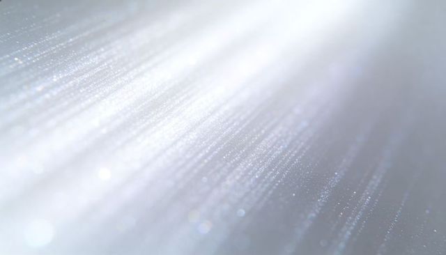 Shimmering diagonal light streaks across frosted surface with bokeh sparkle and glitter