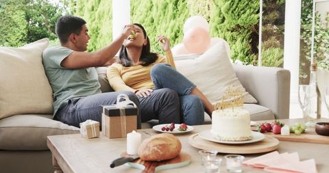 Couple Enjoying Outdoor Birthday Celebration with Cake and Gifts