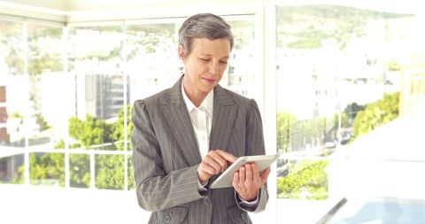 Professional Businesswoman Engaging with Tablet in Modern Office