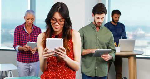 Diverse Team Engaged with Digital Tablets in Modern Office