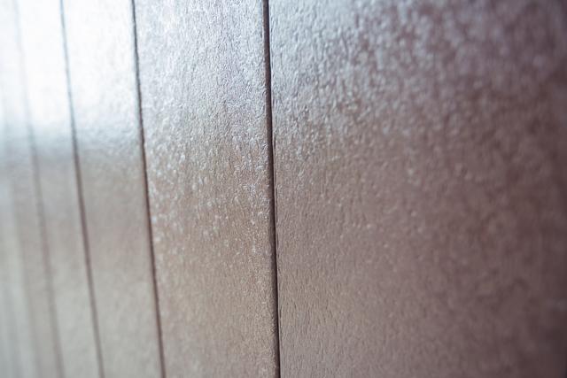 Detailed close-up shot of vertical wooden panels showcasing texture and natural grain. Suitable for use in interior design projects, background designs, website headers, or as a texture overlay in graphic design.