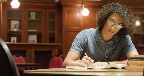 Focused young man studying in library, engaged and attentive
