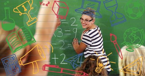 Teacher teaching math at chalkboard smiling with engaged students and colorful icons