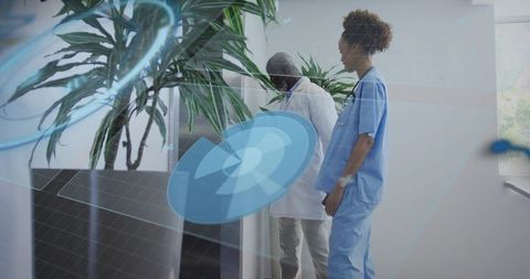 Clinicians examining indoor plants with augmented reality interface in hospital corridor