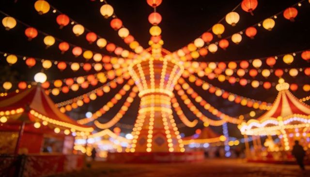 Glowing night carnival ride radiating strings of lanterns with striped tents and carousel