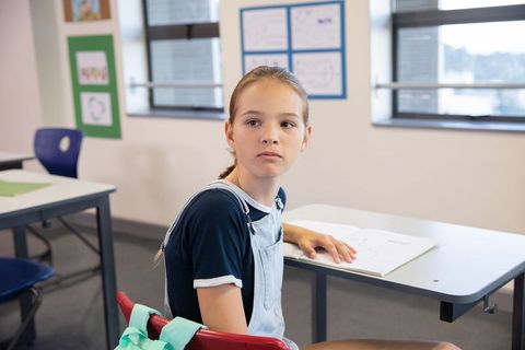 Focused Adolescent Student Sitting at Classroom Desk Studying