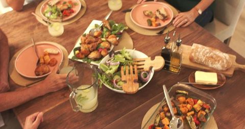 Family Enjoying Home Meal with Fresh Salad and Drinks
