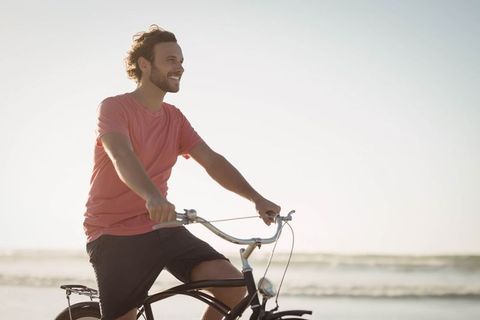 Carefree Man Riding Bicycle on Beach at Sunset - Download Free Stock Images Pikwizard.com